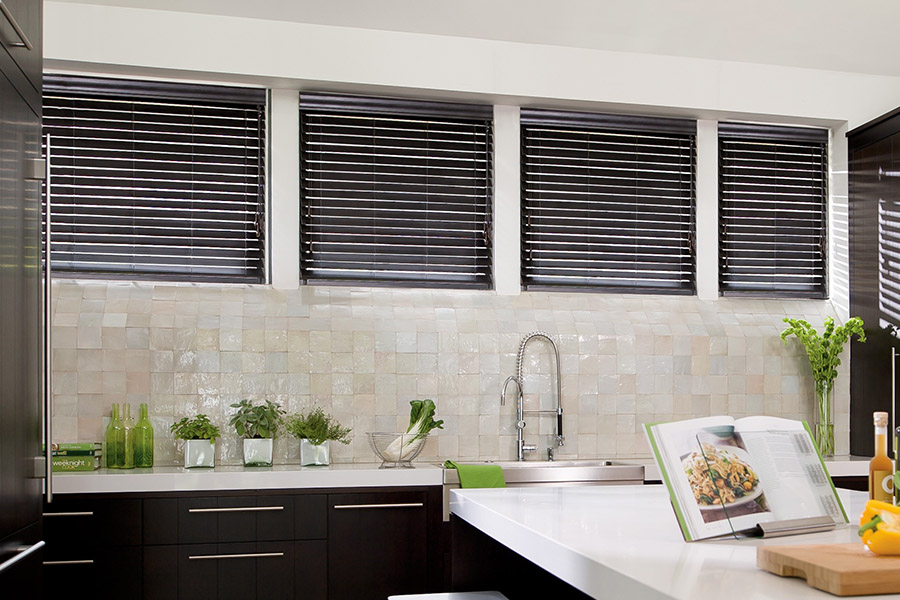 Choose custom Polywood faux wood blinds for your kitchen in Miami. Special shaped faux wood blinds in several windows above a sink.