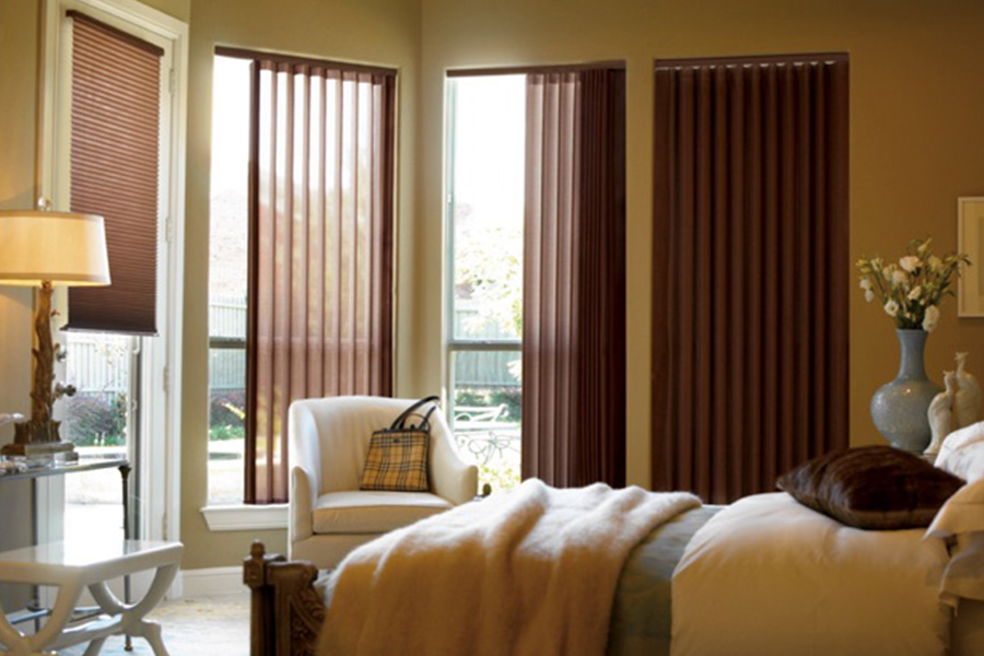 Choose durable and high-quality fabric or vinyl vertical blinds in Miami. Maroon fabric vertical blinds inside a bedroom