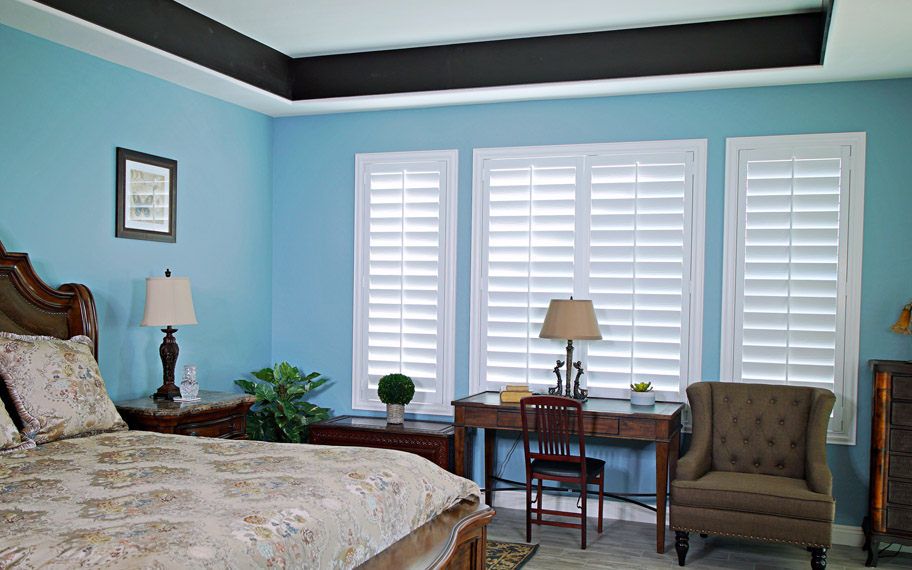Polywood shutters provide insulation for the perfect temperature all year long in Miami. Polywood shutters in a bedroom.